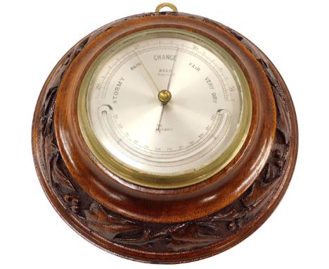 An early 20thC aneroid barometer, the dial stamped Ross Wigmore Street London, in carved walnut case, 22cm diameter. 