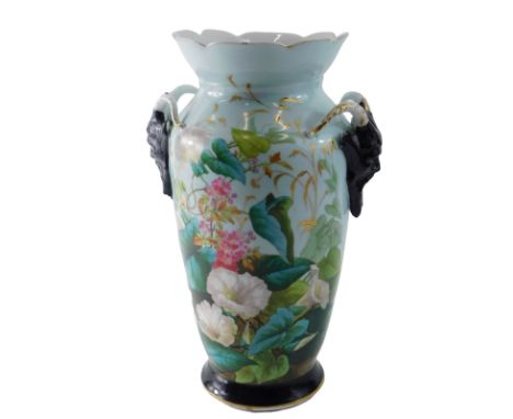 A late 19th/early 20thC Paris porcelain vase, decorated with flowers flanked by black beared goat masks, on an ebonised and g