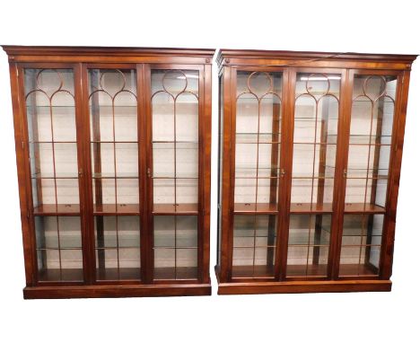 A pair of mahogany display cabinets, in George III style, each with a moulded cornice above two glazed doors flanking a glaze