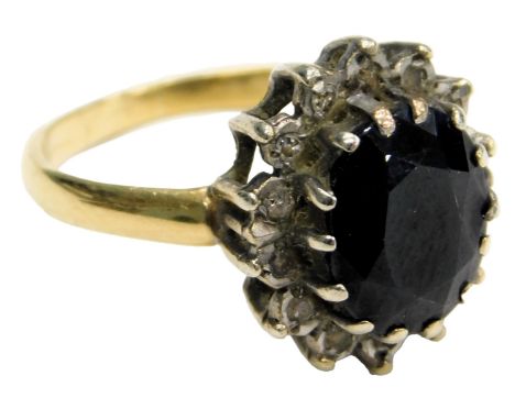 A sapphire and diamond ring, the oval cut sapphire in a surround of tiny brilliant cut diamonds, in a two tier basket setting