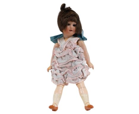 A small German bisque headed doll, with composition limbs, wearing a pink and pale blue dress, 20cm high. 