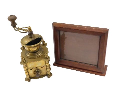 An early 20thC mahogany photograph frame, with moulded border, hinged back, 26cm wide, and a brass coffee grinder. (2)