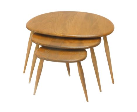 A nest of three Ercol light elm pebble tables, on turned legs, the largest 65cm wide. 