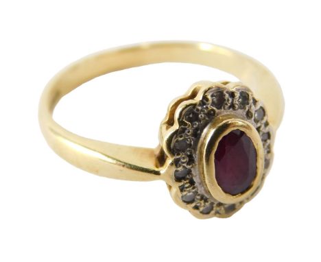 An 18ct gold ruby and diamond ring, the oval cut ruby in a surround of diamonds, in a basket setting, size N, 3.7g.