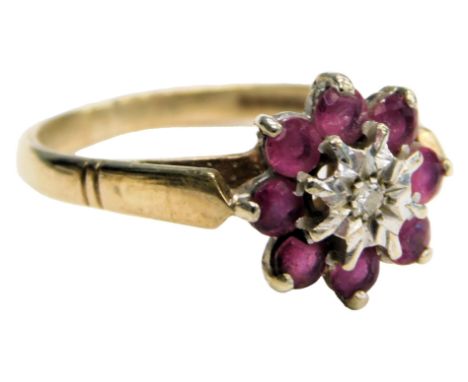  A 9ct gold ruby and diamond flower head ring, the central brilliant cut diamond in a surround of eight rubies, in a basket s