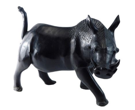 An African ebonised and carved wooden model of a warthog, 43cm long. 