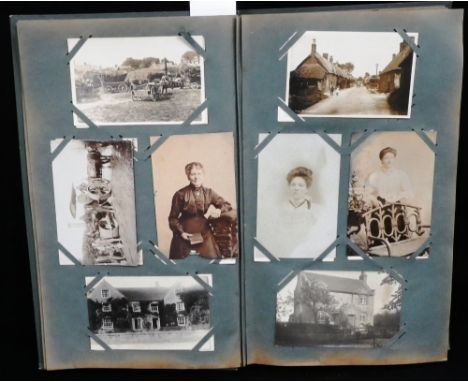 AN EARLY 20TH CENTURY POSTCARD ALBUM containing various subjects including a steam threshing team, a road mending gang with s