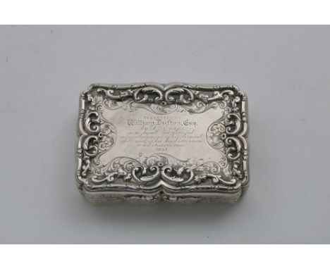AN EARLY VICTORIAN ENGRAVED SNUFF BOX of rectangular serpentine outline with applied scroll borders around the cover and an a