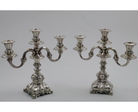 A PAIR OF SCANDINAVIAN THREE-LIGHT CANDELABRA  on lobed and shaped square bases with scroll branches and lobed and fluted cap