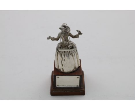 AN EARLY 20TH CENTURY SMALL CAST FIGURAL BELL in the form of a young lady in a crinoline dress and bonnet, peddling her wares