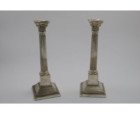 A PAIR OF MID 20TH CENTURY CANDLESTICKS with fluted columns and stepped, square plinth bases, with bead borders and detachabl