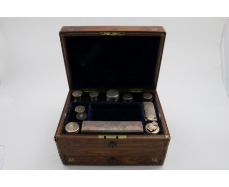 A VICTORIAN BRASS BOUND ROSEWOOD DRESSING CASE fitted with various mounted cut-glass bottles/jars, a powder jar and an inkwel