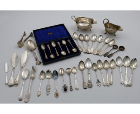 A MIXED LOT:- Two sauce boats, a cased set of six coffee spoons, a pair of filigree sugar tongs, three butter knives, a desse