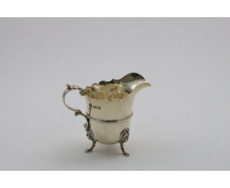 AN EDWARDIAN HELMET-SHAPED CREAM JUG on three lion mask &amp; paw feet, with a moulded girdle and shaped rim, by J. Frazer &a