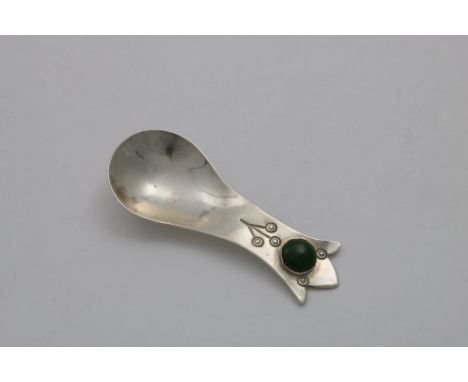 AN EDWARDIAN ARTS &amp; CRAFTS CADDY SPOON with a trefid terminal, cabochon-set with a mottled green enamel/porcelain boss an