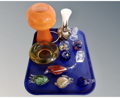 A tray containing glass paperweights, amber glass ashtray, 1970s orange glass table lamp. 
