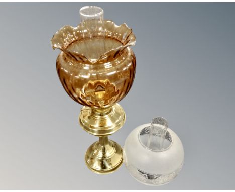 A Victorian style brass based paraffin lamp with tinted glass shade and further glass shade with chimney.