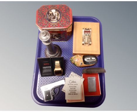 A tray containing boxed Colibri lighter, table lighter in the form of a clog, boxed gent's Accurist wristwatch, table lighter