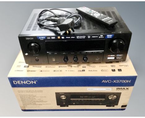 A Denon AVC-X3700H 9.2 channel amplifier with remote control, lead, and box.