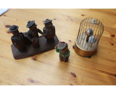 A 1950's Austrian musical toy, in the form of three eldery men in a band, with removable heads for corkscrew, bottle opener a