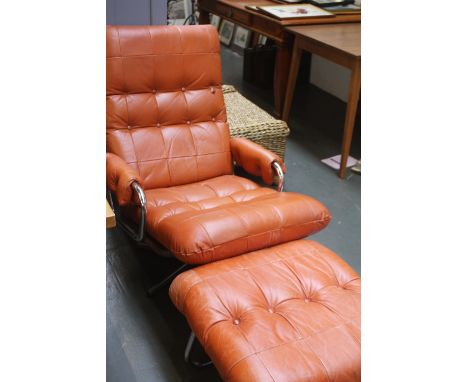 A 1970s Eames style button back armchair and foot stool in tan leather
