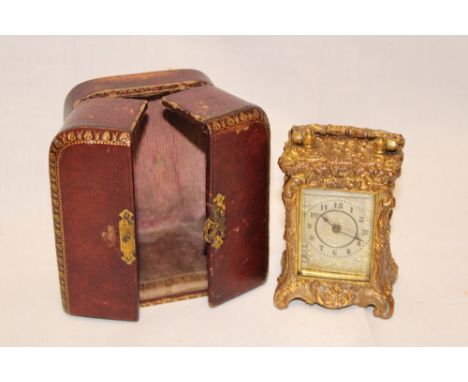 A good quality gilt brass travelling clock with silvered circular dial in scroll case and Morocco leather travelling case 