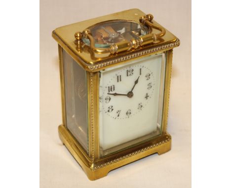 A French carriage clock with porcelain rectangular dial in brass traditional glazed case  