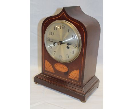 An Edwardian mantle clock with silvered circular dial in inlaid mahogany arched case 