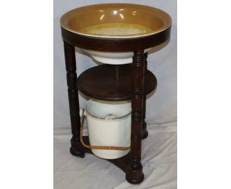 A Victorian stained mahogany circular two-tier wash stand, the top inset with ceramic bowl together with an accompanying cera
