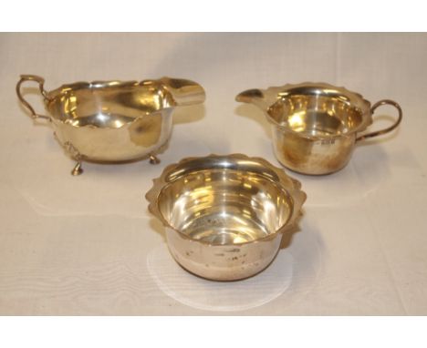 A George V silver classical-shaped sauce boat with scroll handle on hoof feet, Birmingham marks 1914 together with a similar 