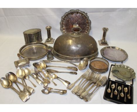 A selection of silver plated items including a pair of candlesticks, oval tea caddy, oval food cover, bottle stand, cutlery e