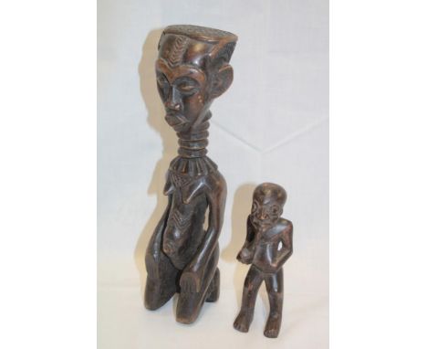 An African carved wood figure of a kneeling female 12" high and one other African carved wood figure of a male with a pipe 6½