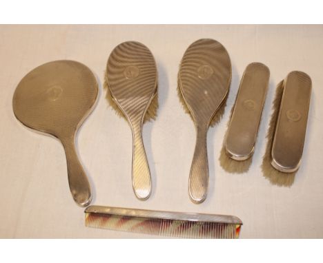 A silver six piece dressing set comprising a hand mirror, pair of matching hair brushes, pair of matching clothes brushes and