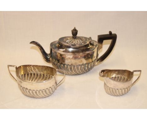 A late Victorian silver oval tea set comprising a small oval teapot with gadrooned decoration and hinged lid together with ma