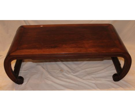 A Chinese rosewood rectangular low coffee table on scroll supports 42½" long
