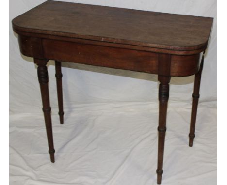 A 19th century mahogany rectangular turnover top card table on turned tapered legs 