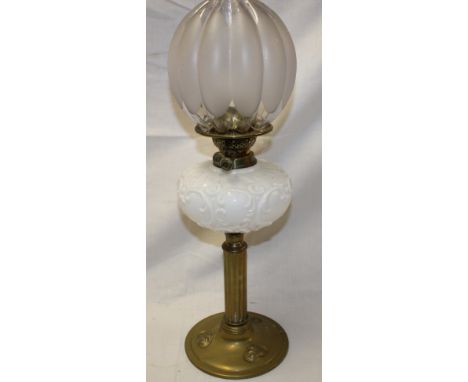 An Art Nouveau brass oil lamp with opaque glass reservoir and frosted glass shade 