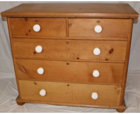 An old polished pine chest of two short and three long drawers with ceramic handles on turned feet, 38" high x 43½" long 