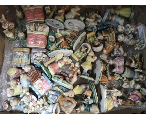 A box containing various ceramic bears and rabbits figure groups