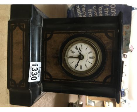 A black wooden mantle clock, the circular dial having Roman Numerals
