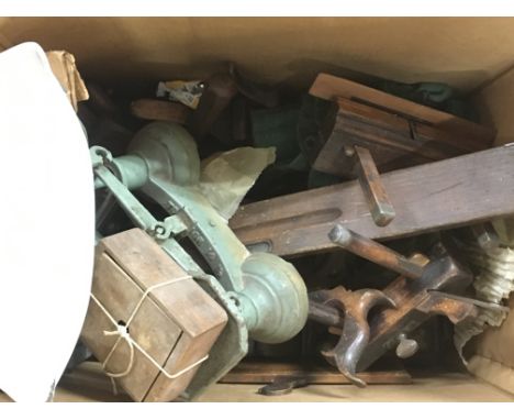 A large collection of vintage woodworking tools including wood planes and a set of scales 
