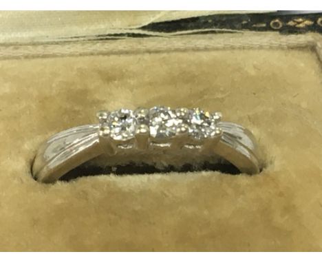 A 9ct white gold ring inset with a row of three diamonds