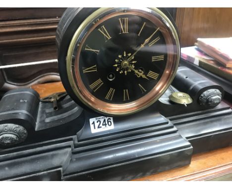 A Victorian slate mantle clock of classical form the circular dial with Roman numerals, with pendulum.