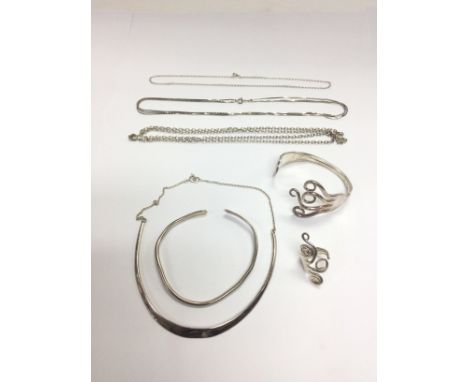 A collection of silver jewellery comprising a silver torque and chain, bangle, ring and chains. Shipping category A.- NO RESE