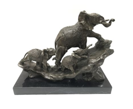 A modern cast bronze elephant figure on a stone base. 30cm wide by 25cm tall.