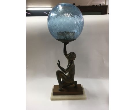 An Art Deco light in the form of lady with a glass shade.