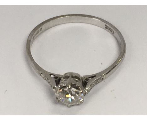 An 18ct white gold solitaire ring flanked by diamond chips