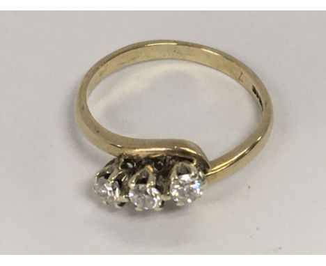 A 9ct gold ring inset with a row of three diamonds