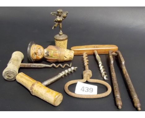 Four various cork screws, a nut cracker and two wine bottle stoppers