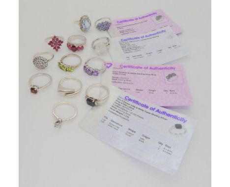 A collection of silver and white metal gem set rings, four with certificates, to include, ruby and diamond accent, amethyst, 